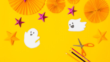 Halloween paper craft flat lay.Children seasonal art table top view.Kids hand craft concept.Bright halloween background with cutted out ghosts and paper crafts.