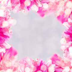 Square frame of gentle pink peonies petals and bokeh lights and copy space for text on light grey.