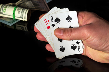 Poker cards with one pair combination. Close up of a gambler hand is holding playing cards in casino