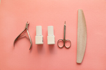 A set of manicure tools on a pink background. Nail care. Top view, flat lay