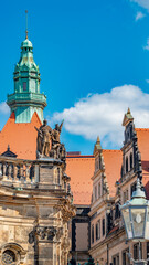 Historical center and colorful old buildings with red roofs and many religious statues in downtown of Dresden in summer with blue sky, Germany, details, closeup.