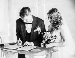 close up. the happy couple by signing a marriage contract.