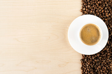 Cup of coffee and coffee beans on the wood table. Copyspace