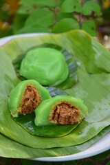 Kue Bugis, Indonesian jajan pasar, traditional snack of glutinous rice flour cake filled with sweet grated coconut, underlined with banana leaf. Popular snack during Ramadan as Takjil