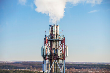 Chimneys in the boiler room against the blue sky. Steam smoke from pipes. Close-up