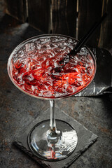 Red alcoholic cocktail with tequila, strawberry syrup and crushed ice, in a cocktail glass, top view