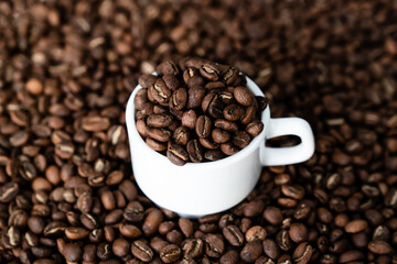 White cup and coffee beans. Closeup view
