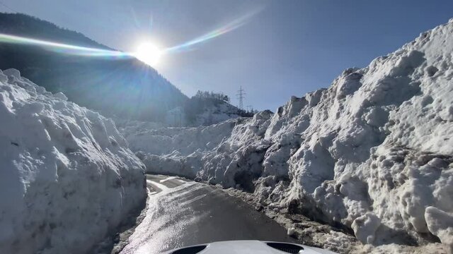Naturkatastrophe in der Schweiz Grengiols 2021. Eine Lawine schneidet die Verbindung zum Dorf ab. Die Strassen wurden wieder ger&auml;umt und ich fahre mit dem Auto durch die Schneemassen.