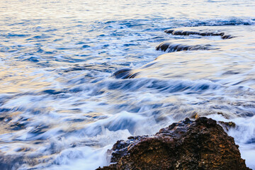 Blurred abstract natural background of sea water with waves and foam. Motion blur. Nature. 