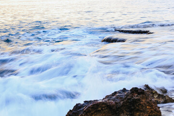 Blurred abstract natural background of sea water with waves and foam. Motion blur. Nature. 