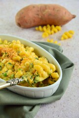 Creamy baked cavatappi pasta with sweet potato, cheddar cheese, peas and spinach garnish with panko crumbs
