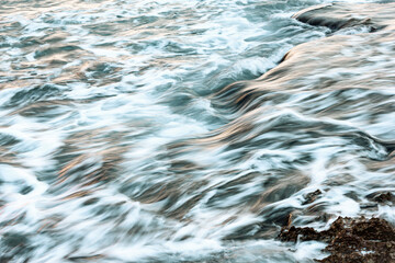 Blurred abstract natural background of sea water with waves and foam. Motion blur. Nature. 