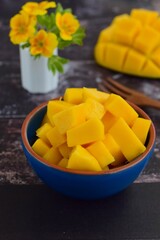 Diced mango cubes served on a bowl. Rustic background. Selective focus