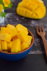 Diced mango cubes served on a bowl. Rustic background. Selective focus