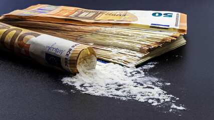 Bundle of euro banknotes and drugs heroin or cocaine on a black background. The concept of...