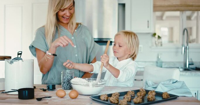 Mother and young child baking cookies together at home in the kitchen, family lifestyle at home