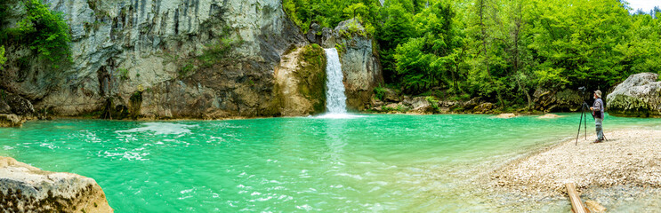 Fototapeta premium photographer sati ozdemir takes photos at the waterfall.