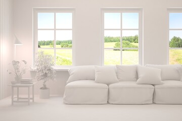 Fototapeta premium Mock up of stylish room in white color with sofa and green landscape in window. Scandinavian interior design. 3D illustration