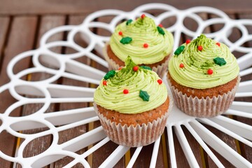 Christmas cupcakes. Muffin with matcha green tea frosting and Christmas decoration sprinkles