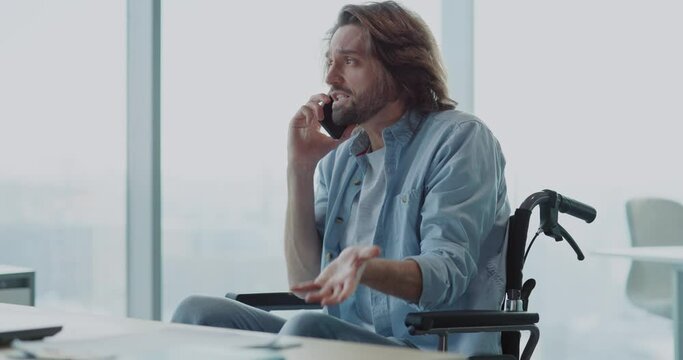 Corporate young handsome caucasian talkatave man speaking in mobile phone conversation to business boss in the office.