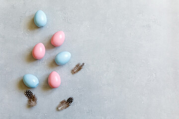 Happy Easter concept. Preparation for holiday. Golden decorated easter eggs feather on concrete stone grey background. Simple minimalism flat lay top view copy space.
