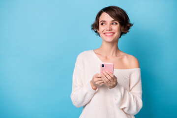 Photo of young lovely pretty smiling happy positive dreamy girl use phone look copyspace isolated on blue color background