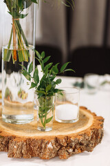 Table setting at wedding reception. Floral compositions with flowers and greenery, candles on decorated table. Coziness and style. Modern event design. selective focus.