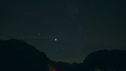 Fototapeta premium Time lapse of Night landscape with mountains and stars.