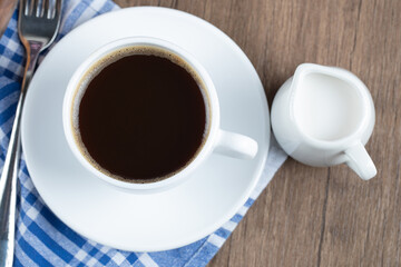 A cup of coffee served wit heavy cream