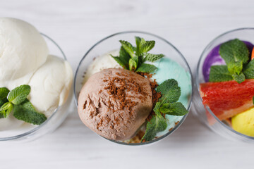 Set of ice cream scoops of different colors and flavors in glass sundae bowls. Summer delicious food, tasty refreshing dessert
