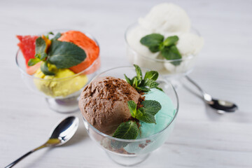 Set of ice cream scoops of different colors and flavors in glass sundae bowls. Summer delicious food, tasty refreshing dessert