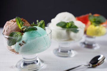Set of ice cream scoops of different colors and flavors in glass sundae bowls. Summer delicious food, tasty refreshing dessert