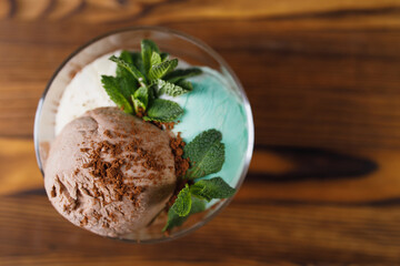 Chocolate, mint and vanilla ice-cream set in sundae bowl, refreshing creamy dessert for summertime. Food background with free space