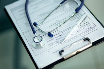close-up. image of a stethoscope, pen and clipboard on the doctor's desktop.