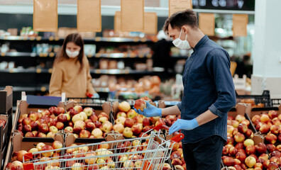 supermarket customers standing near the counter with apples.