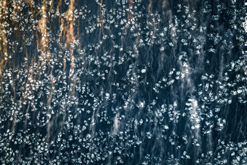 Naklejka na ściany i meble Ice blocks floating in dark waters covered in fog. Abstract landscape in sunny morning light. Picturesque shapes and forms. 