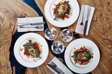 Half baked eggplants with meat, cheese and tomatoes on white background. Banquet festive dishes. Gourmet restaurant menu. White background.