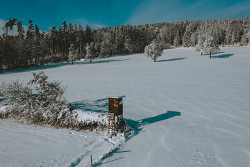 Snow overed landscape with high seat for huntig dear
