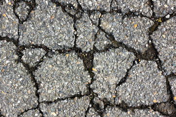 crack in the asphalt, which is made up of small colored stones 