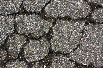 crack in the asphalt, which is made up of small colored stones 