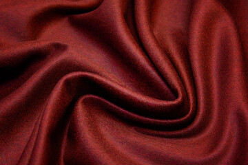 Fototapeta na wymiar Red woolen fabric with waves. Crumpled fabric. Woolen fabric for coat