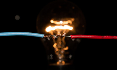 connected cables lighting a light bulb