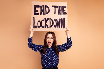 Photo of angry protester lady in glasses formal wear showing placard end lockdown isolated on beige color background
