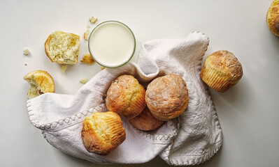 Muffins mit Quark serviert mit Milch auf weißer Serviette. Weißer Hintergrund.