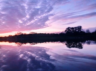 Coucher de soleil sur la Maine (Anjou, France), avec un effet miroir parfait du ciel sur l'eau