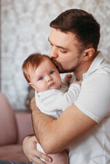 Communication of a beautiful young father with a newborn daughter in his arms