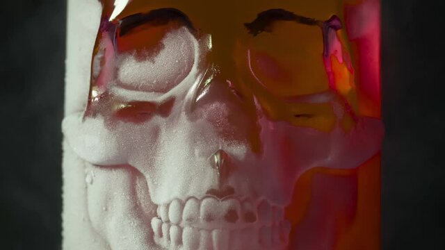 Red Glass Skull in Frost. A glass vessel with a bright, rich red content in the form of a glass skull, cooled by liquid evaporating nitrogen