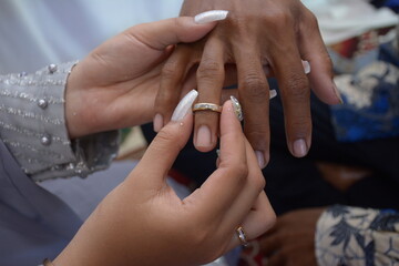 a man's hand inserts the ring into the finger of the bride. wedding photo concept