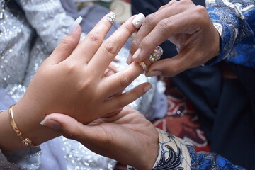 a man's hand inserts the ring into the finger of the bride. wedding photo concept