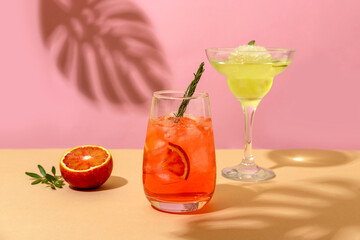 Popular summer ice alcoholic cocktails served under the summer sun light. Trendy style with shadows.